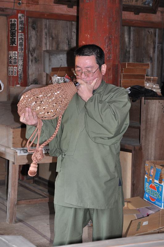 foto_20101118_1511_01.jpg - [de]Ein Mönch spielt uns ein kurzes Stück auf einer Muschel.[en]A monk is playing some tunes on a sea shell.